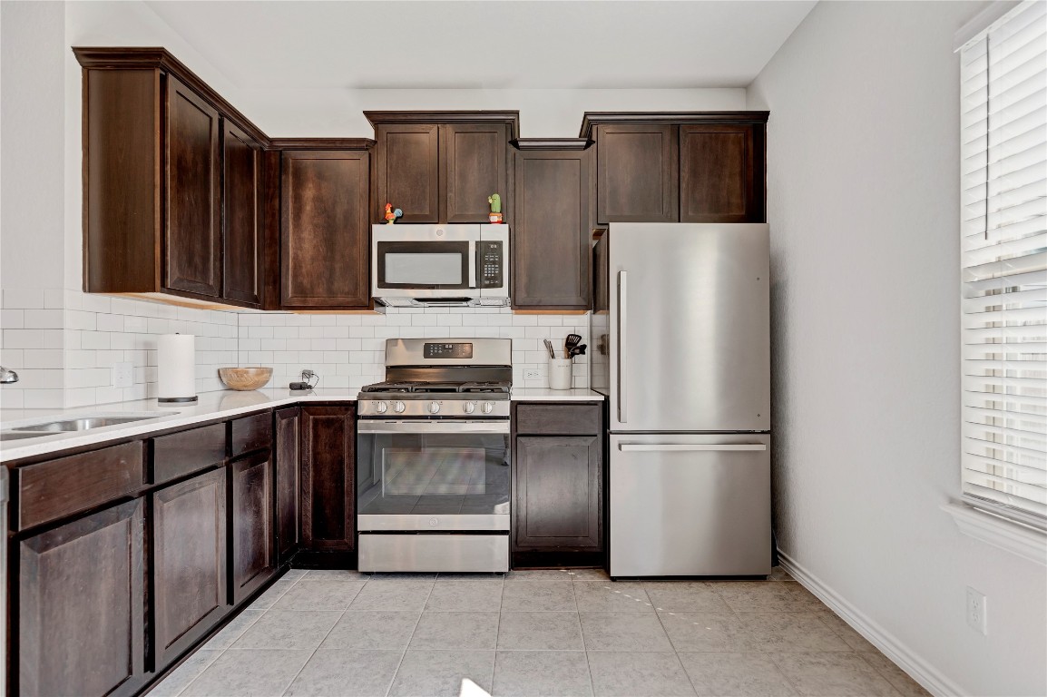380 Witchhazel Way San Marcos, TX 78666 - Photo 8 of 22 a kitchen with stainless steel appliances granite countertop a refrigerator stove a sink and dishwasher