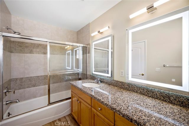 a bathroom with a granite countertop sink and mirror