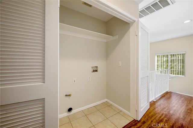 a view of a hallway with wooden floor and a bathroom