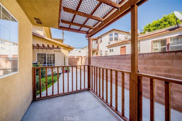 a view of a porch with wooden floor and iron stairs