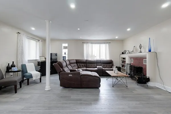 a living room with furniture kitchen view and a fireplace