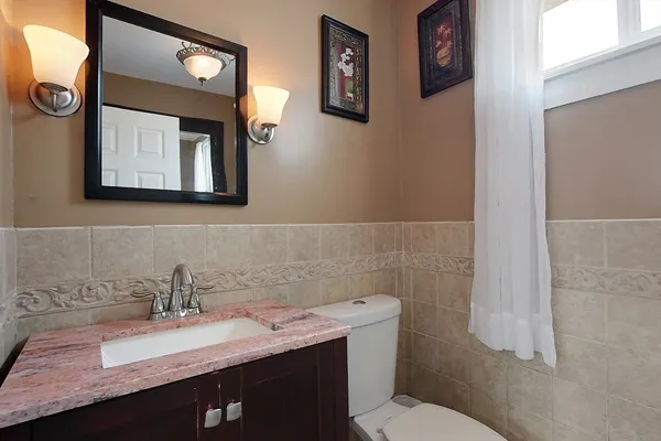 a bathroom with a granite countertop sink mirror and toilet