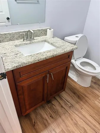 a bathroom with a granite countertop toilet sink and mirror