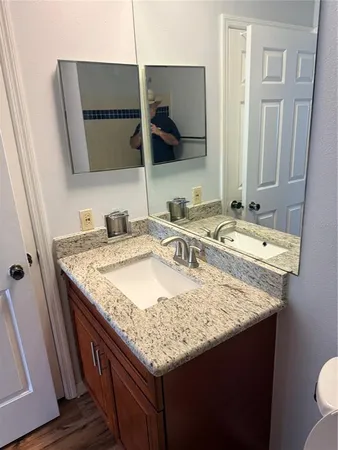 a bathroom with a granite countertop sink and a mirror