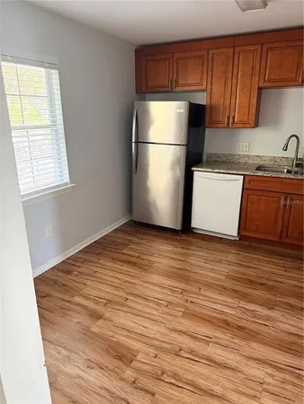 a kitchen with wooden floors and refrigerator