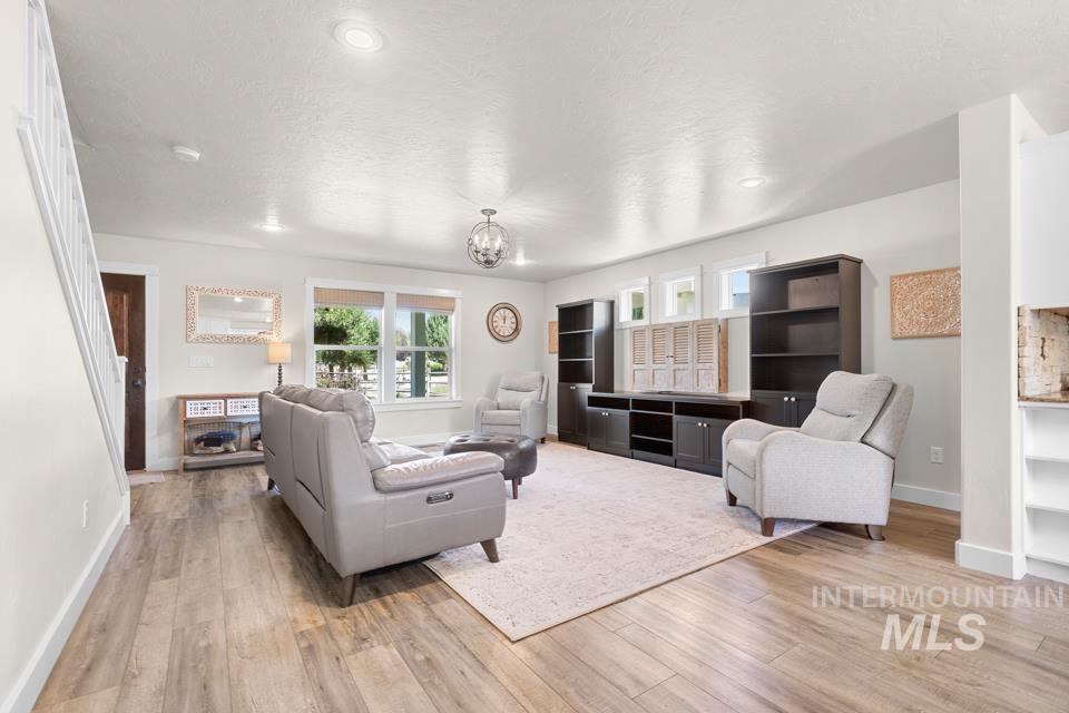 23800 Breyer Road Caldwell, ID 83607 - Photo 7 of 50 Bright living space featuring wood-finish flooring, recessed lighting, and a contemporary chandelier