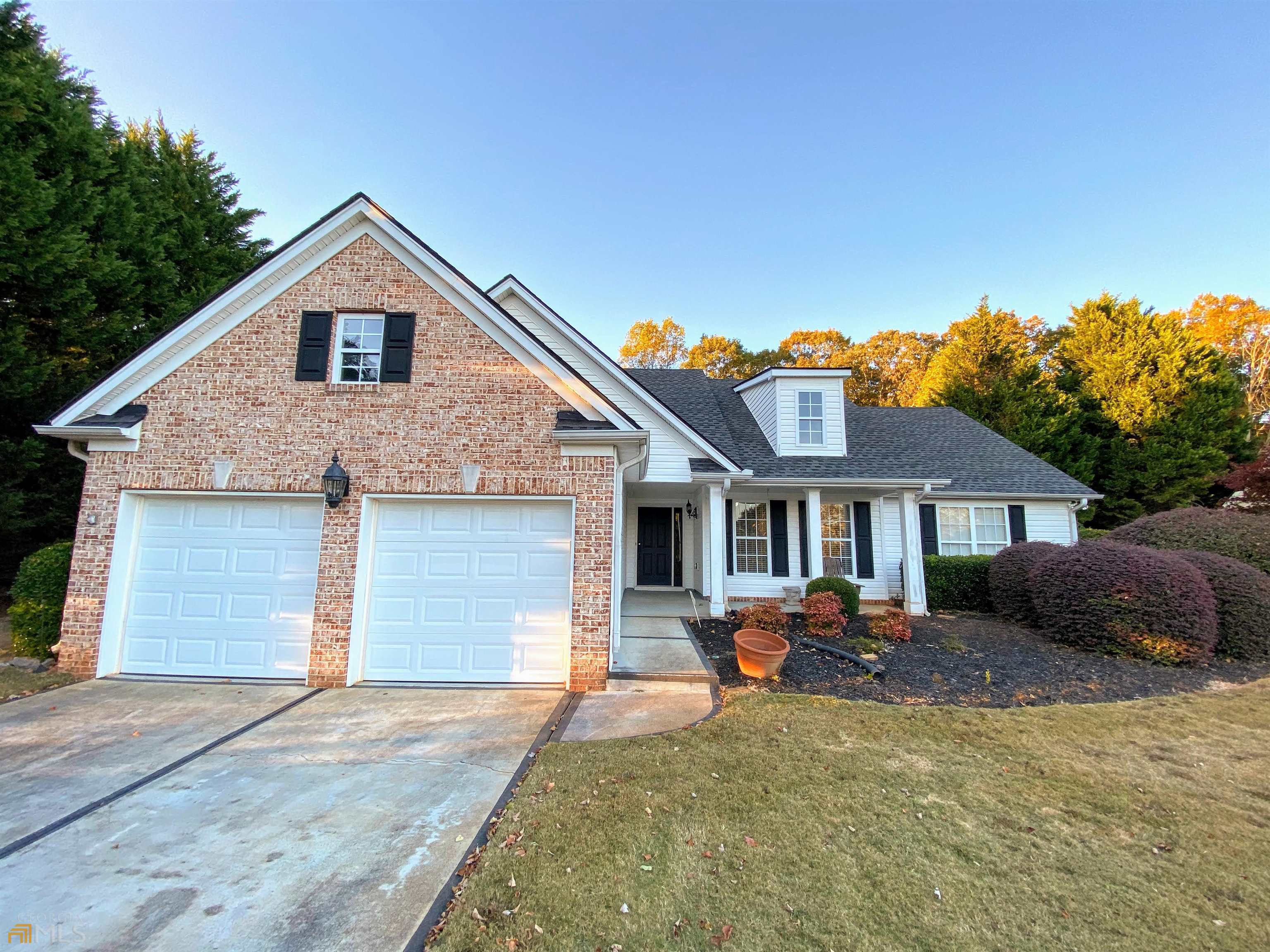 a front view of house with yard and trees in the background