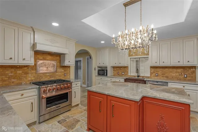 a kitchen with stainless steel appliances granite countertop a stove sink and cabinets
