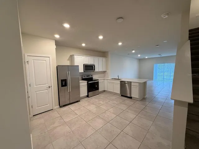 a kitchen with stainless steel appliances a refrigerator sink and microwave