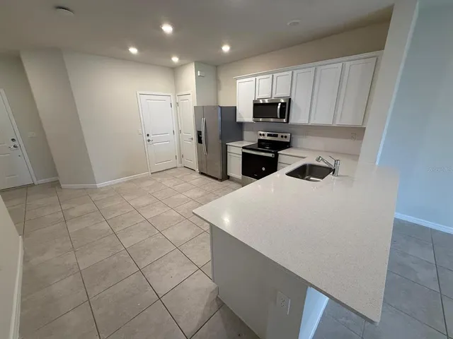 a kitchen with stainless steel appliances a refrigerator sink microwave and cabinets
