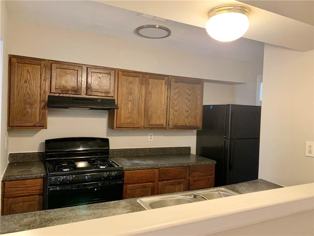 2046 Oak Park Lane Decatur, GA 30032 - Photo 6 of 14 a kitchen with granite countertop wooden cabinets and stainless steel appliances