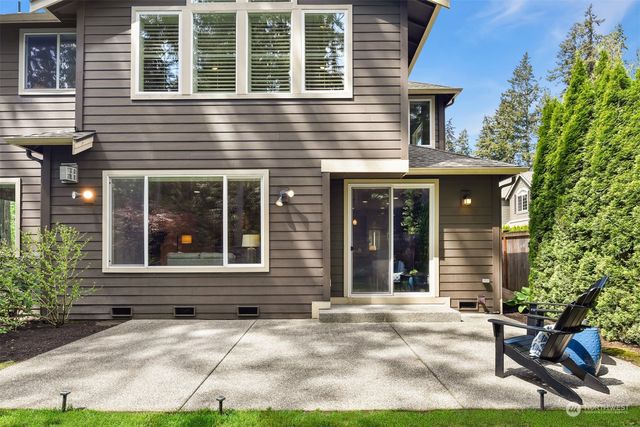 a view of a brick house with large windows and plants