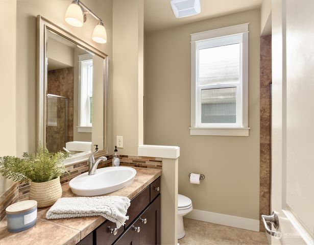 a bathroom with a granite countertop sink and a mirror