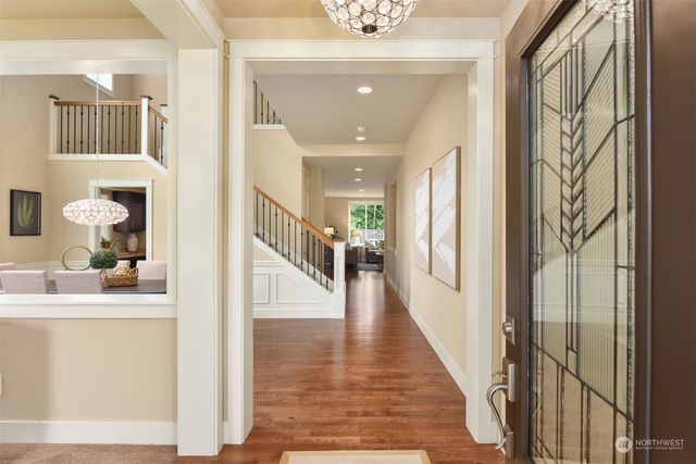 a hallway with wooden floor and staircase