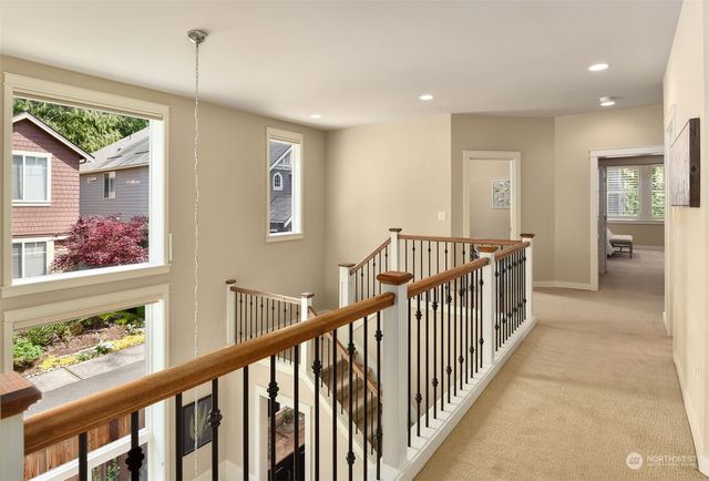 a view of hallway with wooden floor and windows