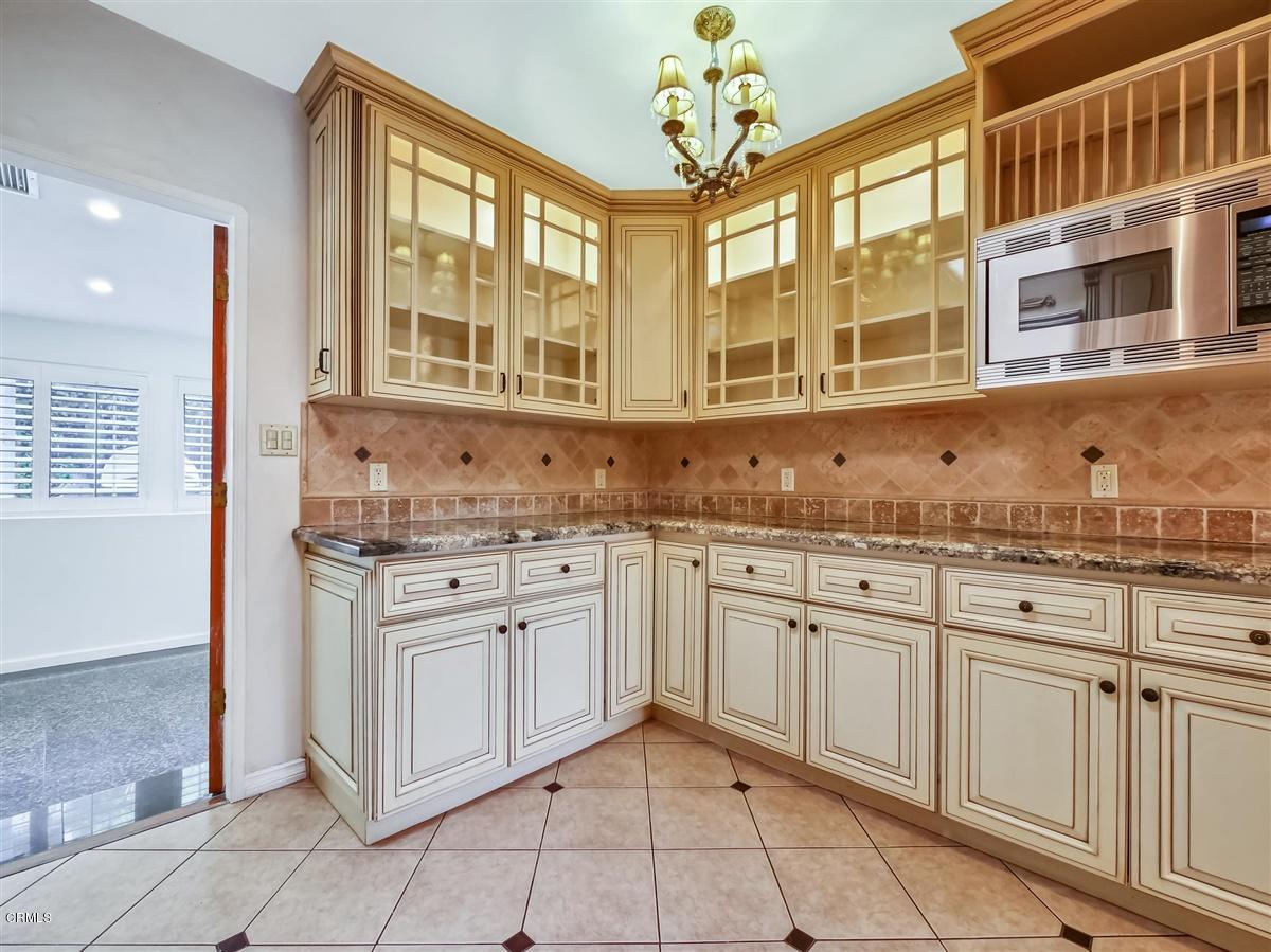 1501 Broadview Drive Glendale, CA 91208 - Photo 17 of 39 a kitchen with granite countertop white cabinets white appliances with a dining table and chairs