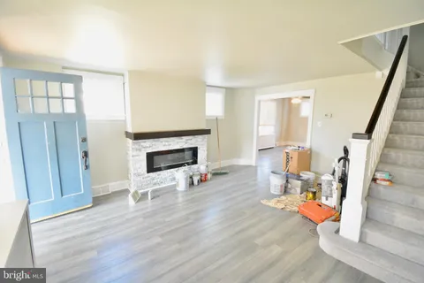 a view of a livingroom with wooden floor and a fireplace