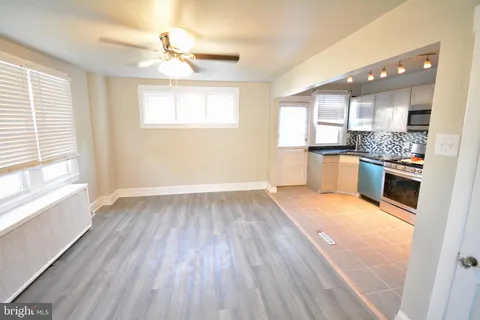 a view of a kitchen with wooden floor and stainless steel appliances
