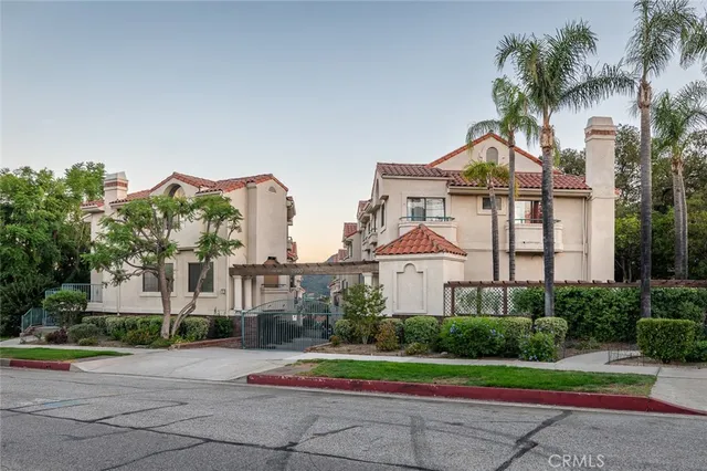 a front view of a house with a yard and potted plants