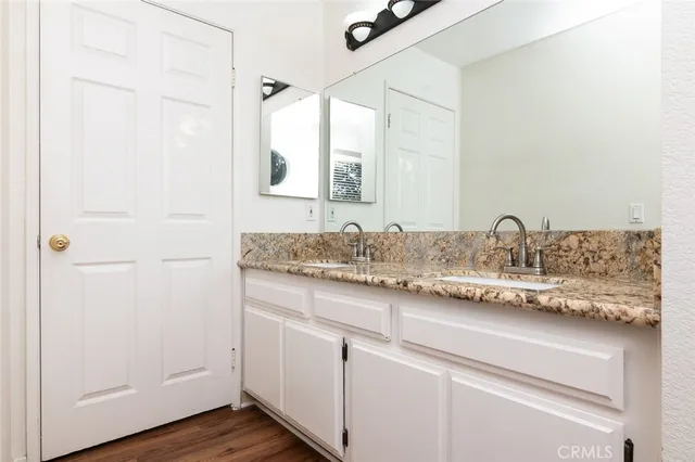 a bathroom with a granite countertop sink a toilet and shower