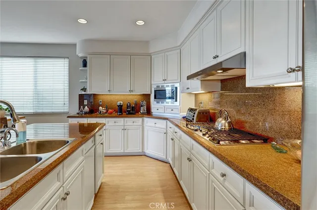 a kitchen with a sink stove top oven and cabinets
