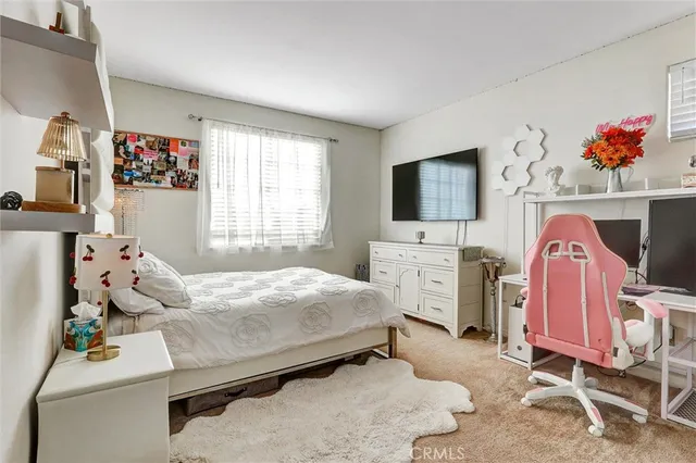 a bedroom with bed and flat screen tv