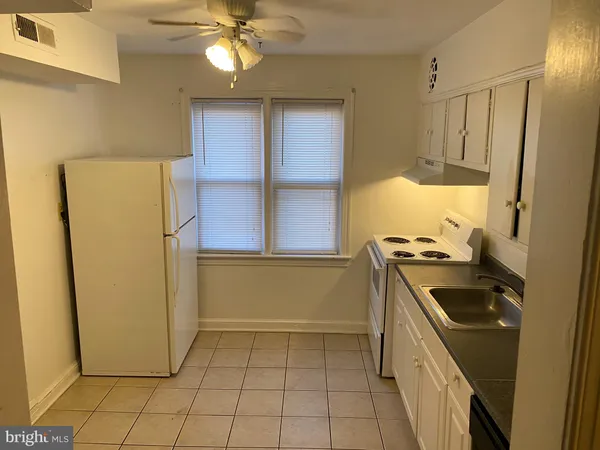 a kitchen with a refrigerator and a stove top oven