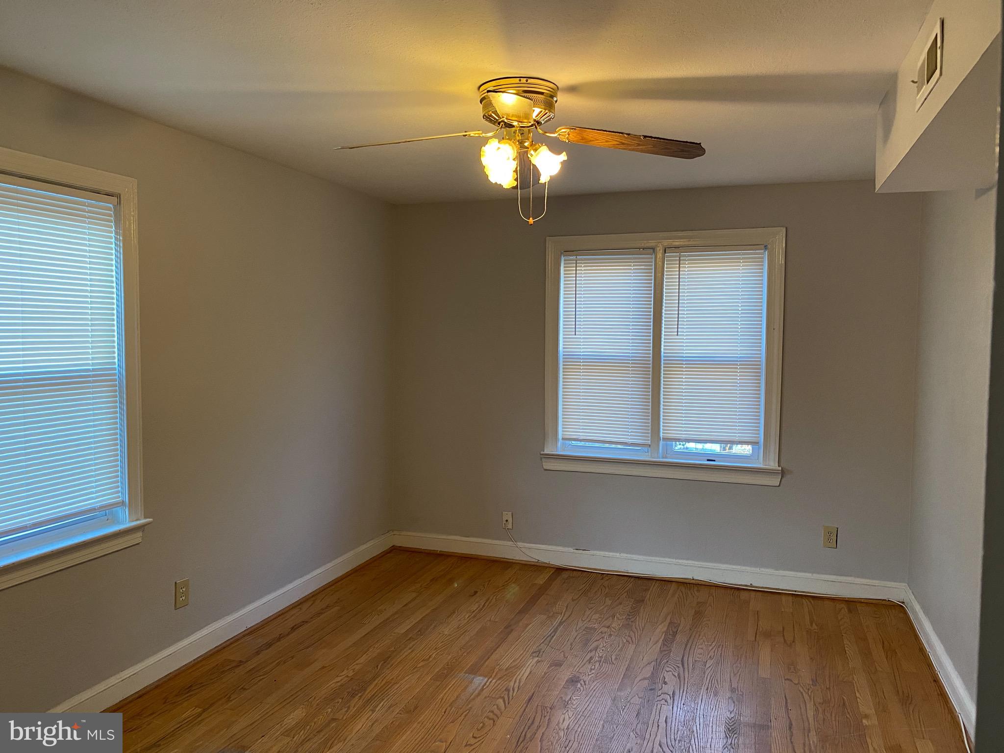 4236 Benning Road Northeast, Unit 302 Washington, DC 20019 - Photo 7 of 12 a view of an empty room with wooden floor and a window