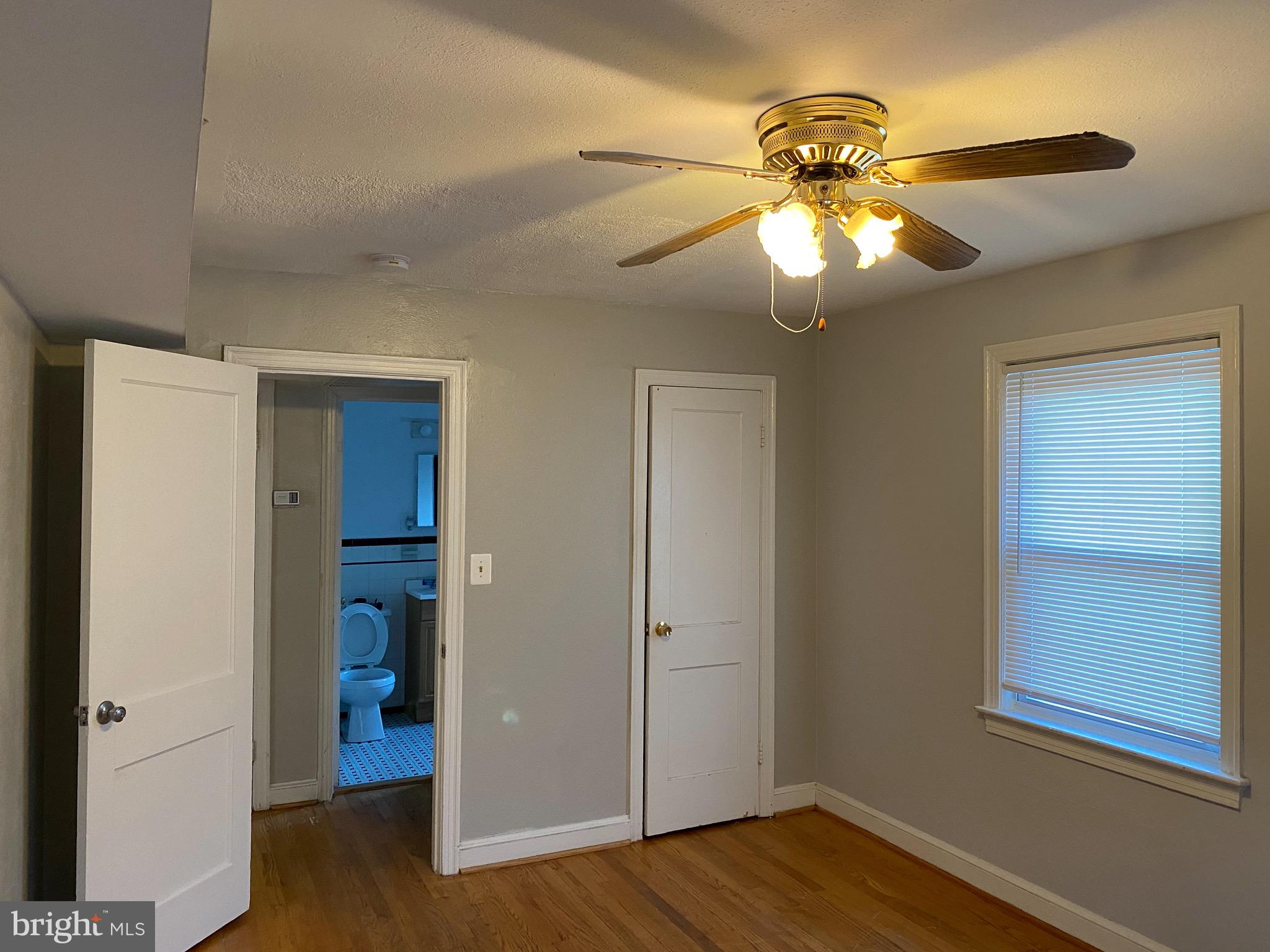 4236 Benning Road Northeast, Unit 302 Washington, DC 20019 - Photo 8 of 12 a view of an empty room with wooden floor and a window