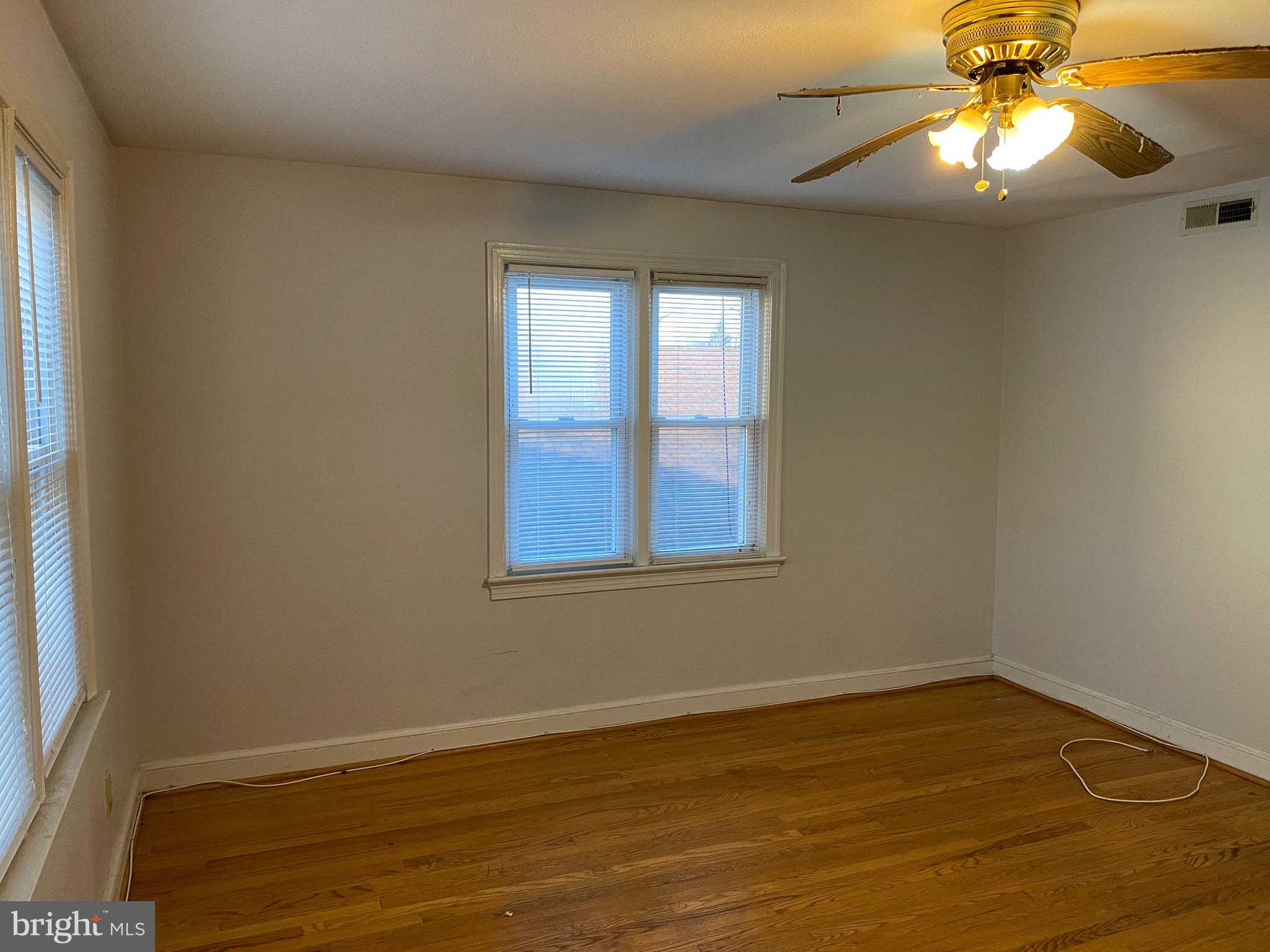 4236 Benning Road Northeast, Unit 302 Washington, DC 20019 - Photo 9 of 12 a view of an empty room with wooden floor and a window