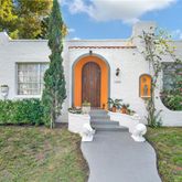 a front view of a house with outdoor seating and green space