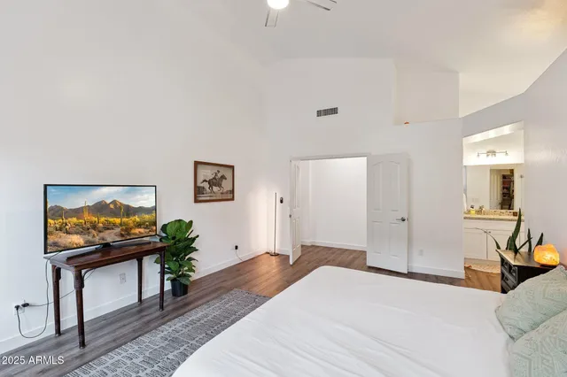 a spacious bedroom with a bed table and a couch
