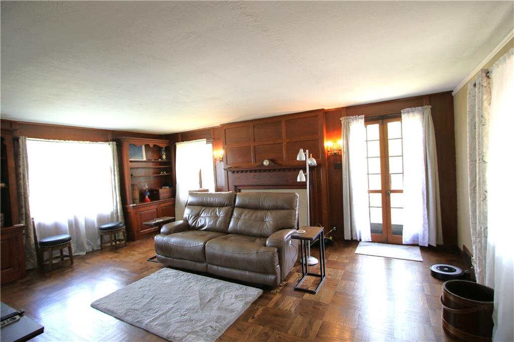 1121 Try Street Monongahela, PA 15063 - Photo 2 of 38 Gorgeous Woodwork in Spacious 20x15 Living Room including Original Built-in Book Shelves & Stunning Wood Burning Fireplace w/ Marble Hearth & Original Candle Sconces on both sides. Gorgeous Original Paquet Wood Floors just refinished Sept 2023. Glass French Doors lead to Large Yard!