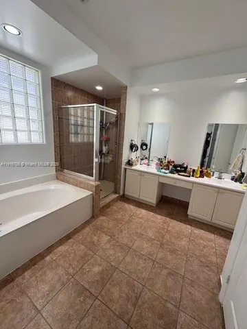a spacious bathroom with a tub sink and mirror