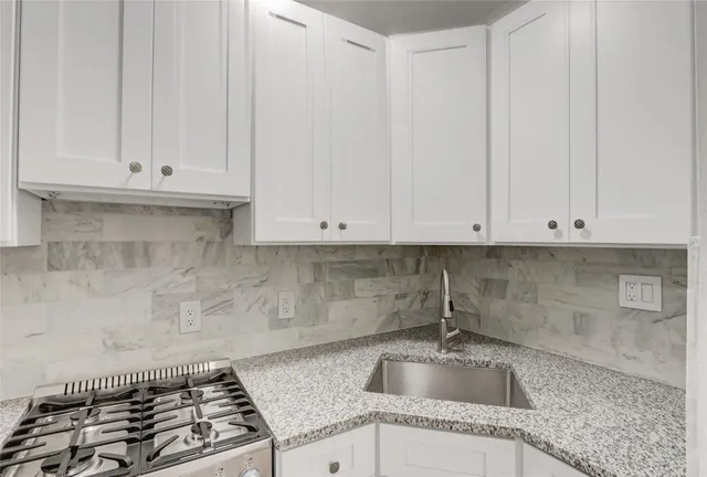 a kitchen with granite countertop a sink and a white stove