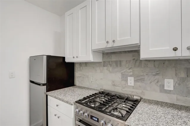 a kitchen with stainless steel appliances white cabinets and a stove