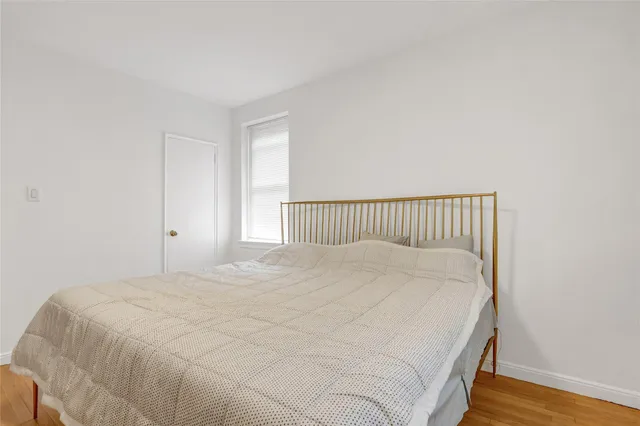 a large bed sitting in a bedroom next to a window