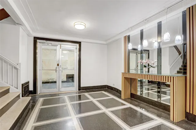 a room with a black white checkered floor with a large mirror and a potted plant on it