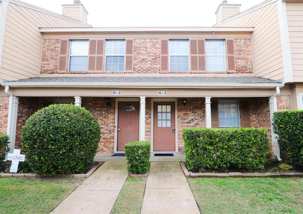 View of front facade featuring a chimney, brick siding, and a porch