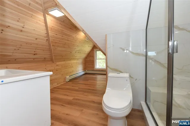 a bathroom with a sink toilet a mirror and shower