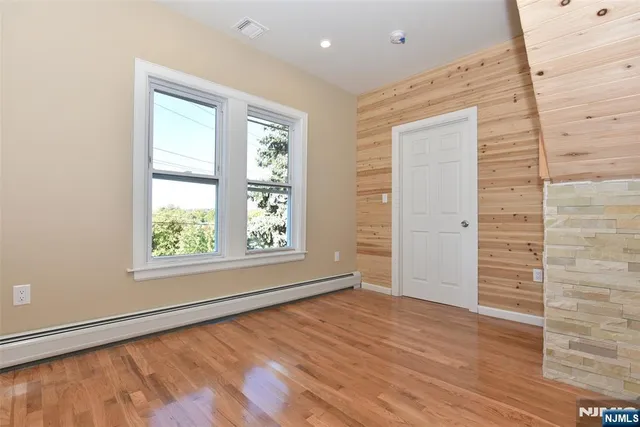 a view of empty room with wooden floor and fireplace