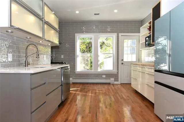 a kitchen with stainless steel appliances a stove a sink and a window