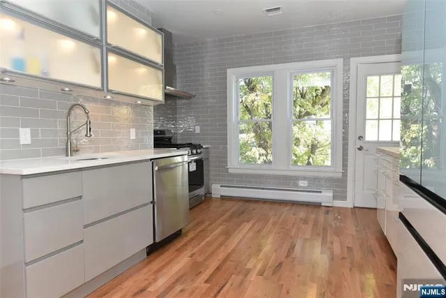 a kitchen with stainless steel appliances white cabinets and a refrigerator
