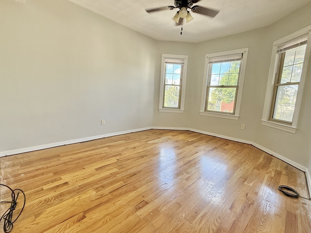 184 Boston Street, Unit 2 Boston, MA 02125 - Photo 5 of 14 wooden floor in an empty room with a window