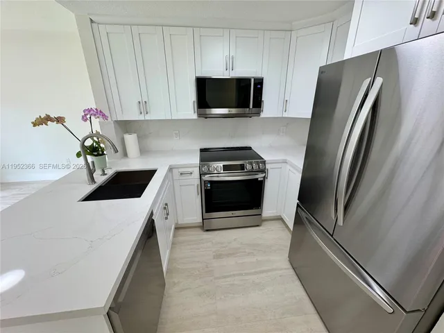 a kitchen with a refrigerator sink and microwave