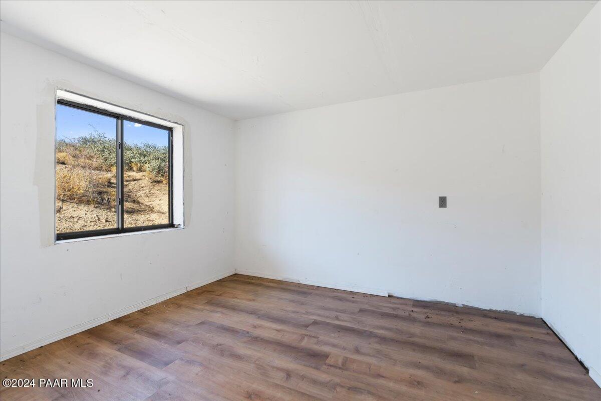17400 Round Mountain Road Dewey, AZ 86327 - Photo 9 of 25 a view of an empty room with wooden floor and a window