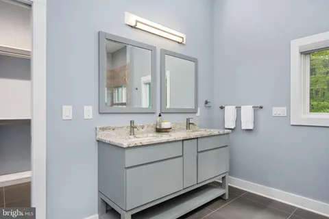a bathroom with a granite countertop sink a mirror and a toilet