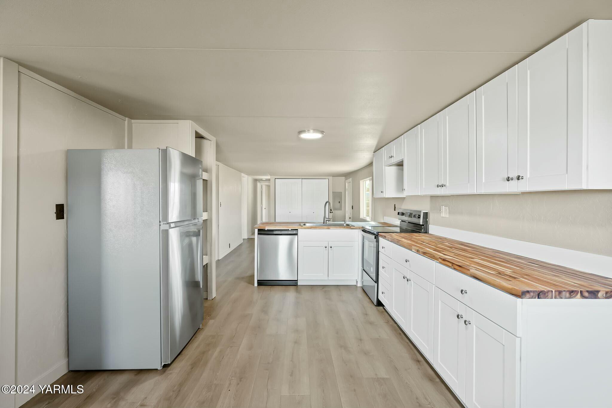 590 Hideaway Road Yakima, WA 98908 - Photo 10 of 34 a large kitchen with white cabinets stainless steel appliances and a refrigerator