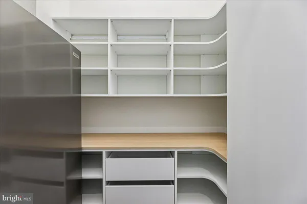 a kitchen with a refrigerator and white cabinets