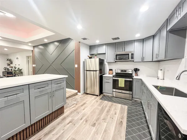 a kitchen with refrigerator a microwave and cabinets